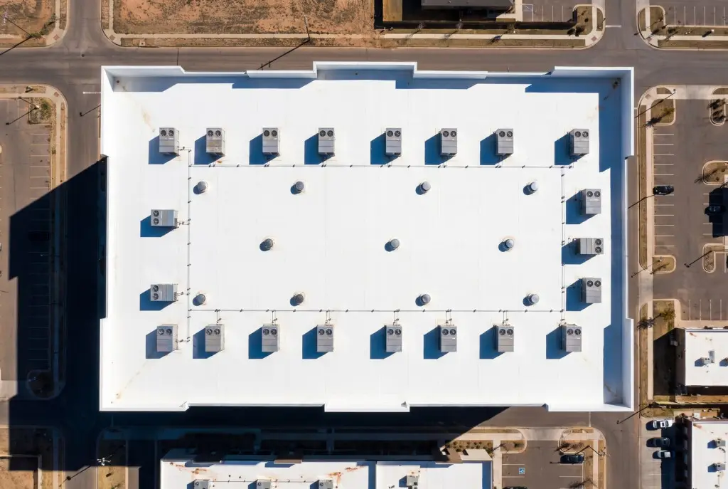 Aerial view of a finished white TPO commercial roof with rooftop HVAC units on a modern Lubbock business building