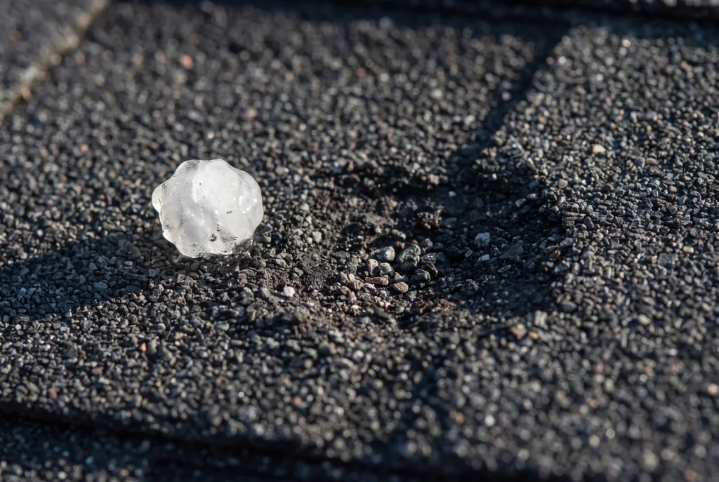 Close-up of hail bruising and granule loss driving hail damage roof repair in Lubbock
