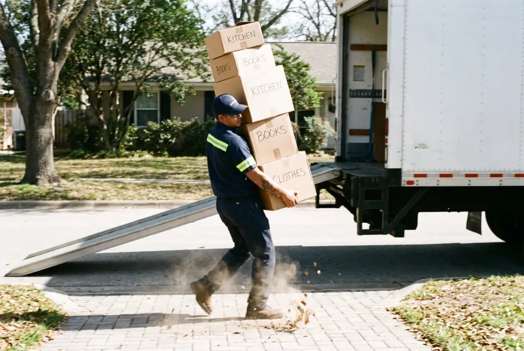 Last-minute movers in Lubbock in matching uniforms quickly loading a clean moving truck for a same-day move outside a modern apartment