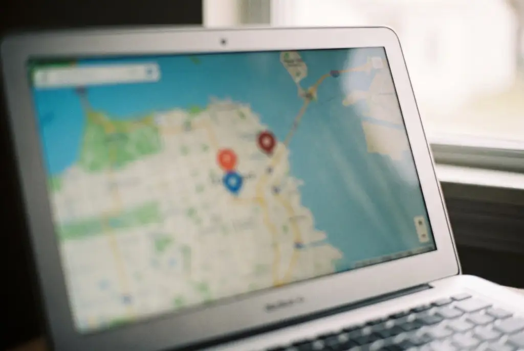 Lubbock marketer reviewing local SEO map pack rankings for a small business on a laptop in a bright modern office, screen blurred with no readable text